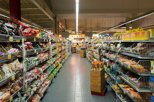 Location Wide supermarket aisle with boxes and stock piled on the floor