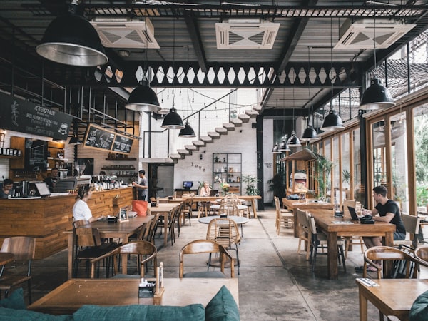 Location Interior of a wide restaurant with wooden tables and pendant lamps