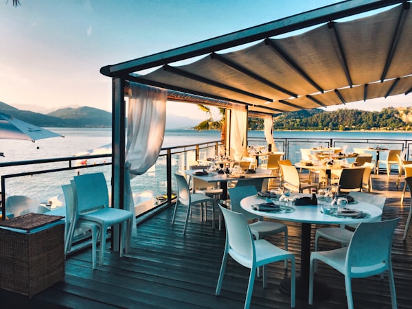 Location Restaurant terrace with tables facing the water at sunset