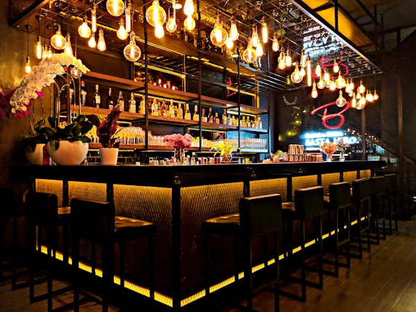 Location Bar counter with hanging bulb lights and tall stools