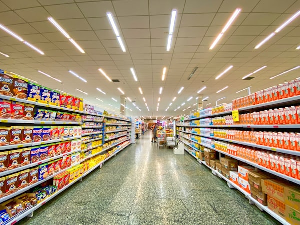 Location Wide, brightly lit warehouse-store aisle with drinks stacked on both sides
