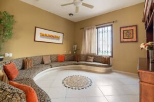 Spaces Living room with a long curved sofa built around a tiled medallion on the floor