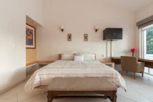 Spaces Bedroom with a bench at the foot of the bed and a desk with an armchair