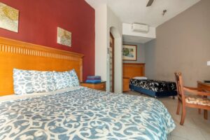 Spaces Bedroom with a red wall, a wooden headboard and a patterned bedspread