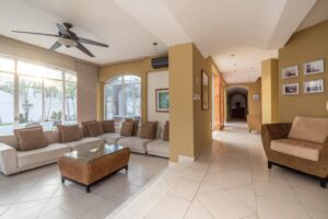 Spaces Living room with an L-shaped sofa, a wicker coffee table and arched windows