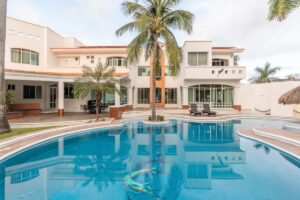 Spaces The pool from the far end, with the two-storey villa and a palm tree behind it