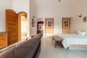 Spaces Bedroom with a wooden arched door, a sofa in the foreground and framed prints