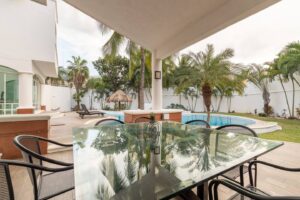 Spaces Glass dining table on the covered terrace, looking out to the pool and the garden